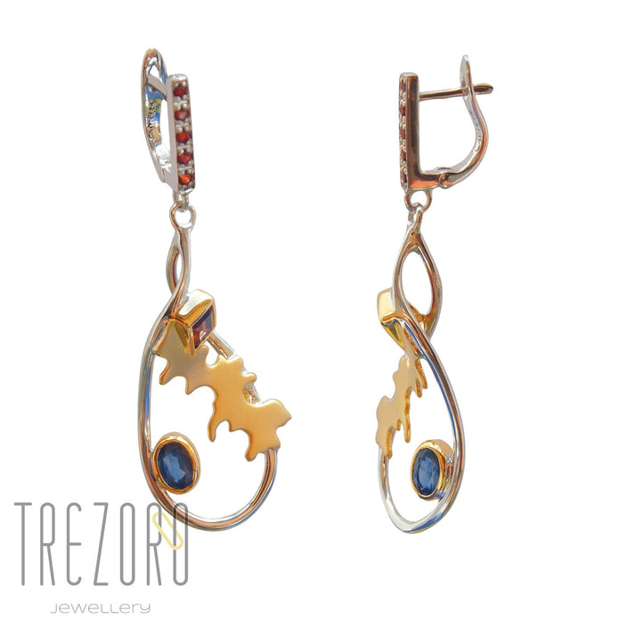Adventure Road Designer Earrings. Sterling Silver with Garnet Sapphire. Rhodium and Gold Plated. On white.